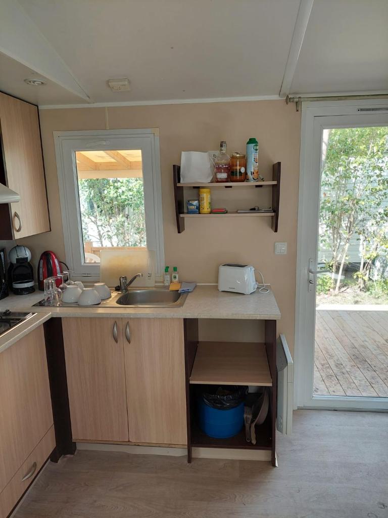- une cuisine avec un évier et un comptoir avec une fenêtre dans l'établissement Mobil-home Le 154 aux Iscles, à La Roque-dʼAnthéron 6 autres photos