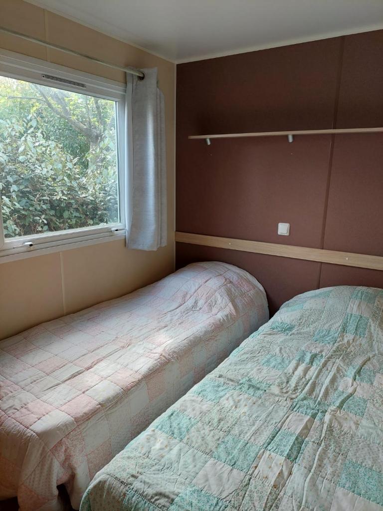 une chambre avec un lit et une fenêtre dans l'établissement Mobil-home Le 154 aux Iscles, à La Roque-dʼAnthéron
