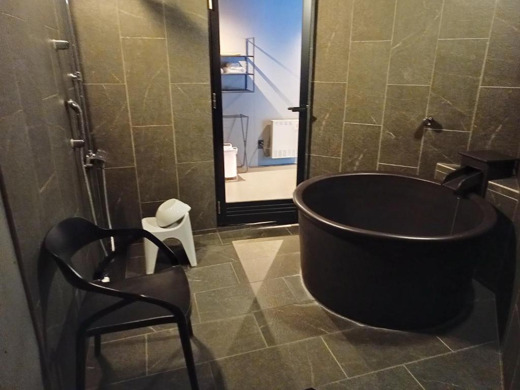 une salle de bain avec une baignoire noire et une douche dans l'établissement グランピングヴィレッジ富士河口湖, à Narusawa