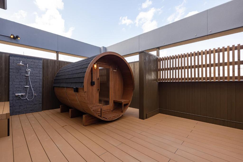 - une grande salle de bains avec une baignoire en bois au milieu dans l'établissement 汐の丸, à Imabari