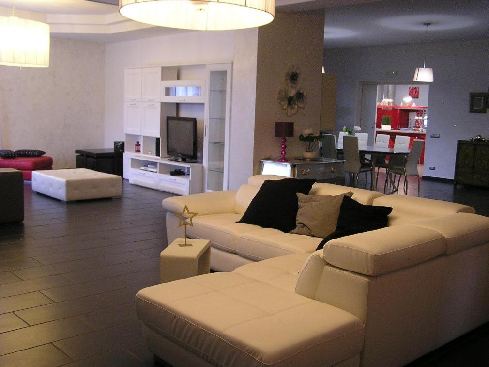 un salon avec un canapé blanc et une télévision dans l'établissement Villa Caterina, à Deruta