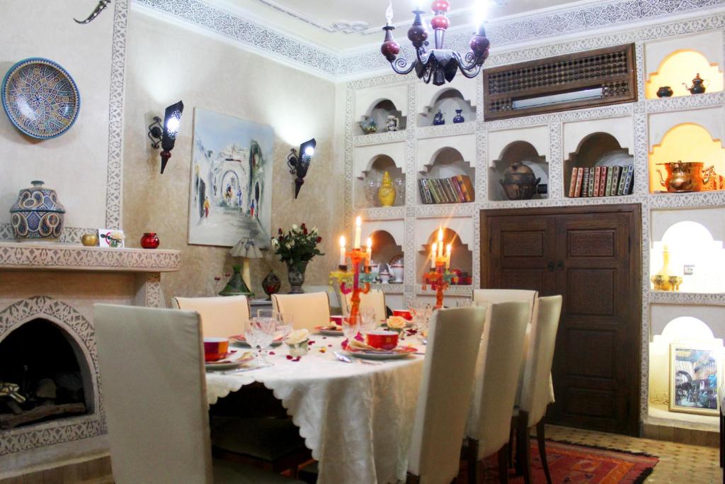 une salle à manger avec une table et une cheminée dans l'établissement Riad Alida, à Marrakech