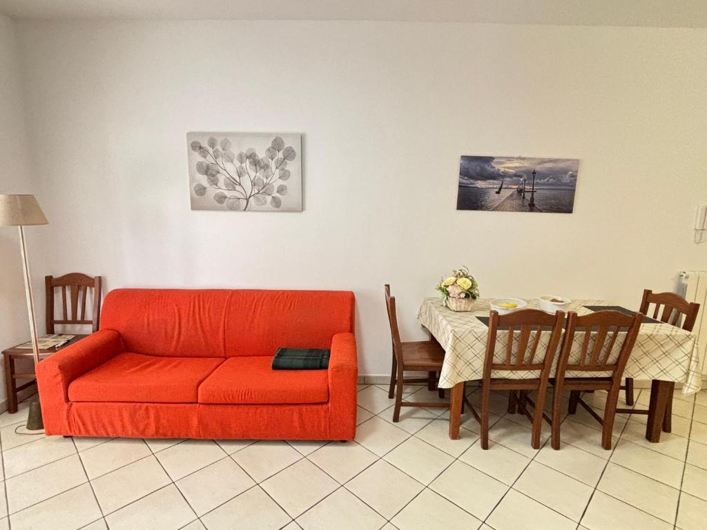 un salon avec un canapé rouge et une table dans l'établissement Rosa Virginia Apartment, à Gallipoli