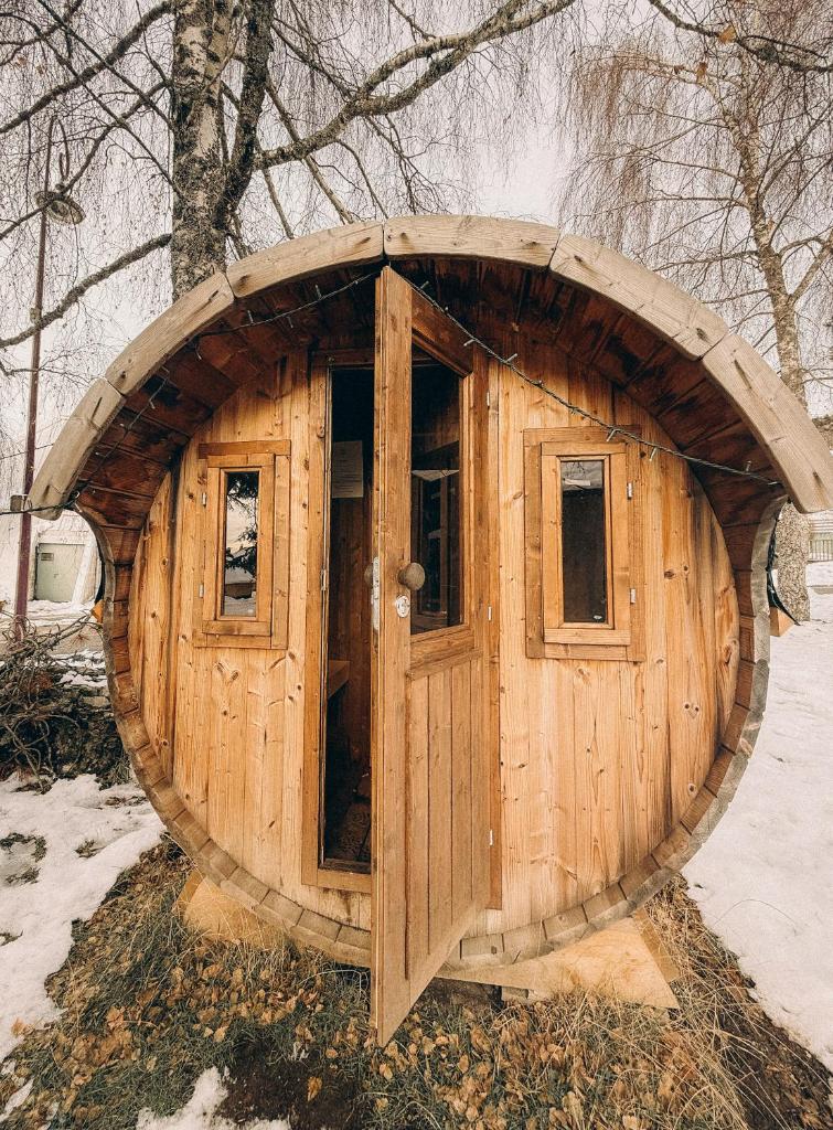 une maison de passe-temps en bois avec une porte ronde dans l'établissement Le Relais Nordique, à Giron