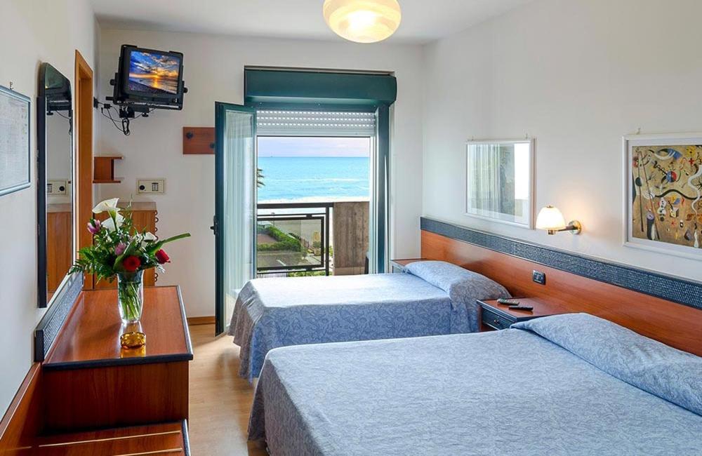 une chambre d'hôtel avec deux lits et une fenêtre dans l'établissement Hotel Tassoni Maison, à Alba Adriatica