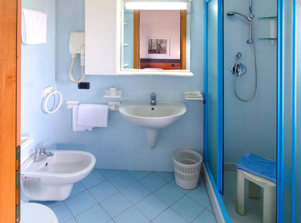 une salle de bain bleue avec un lavabo et des toilettes dans l'établissement Hotel Tassoni Maison, à Alba Adriatica 25 autres photos