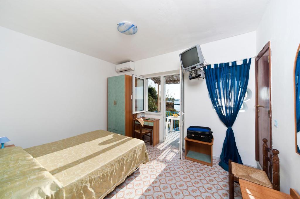 une chambre avec un lit, une télévision et une fenêtre dans l'établissement Residence Hotel La Rotonda Sul Mare, à Ischia