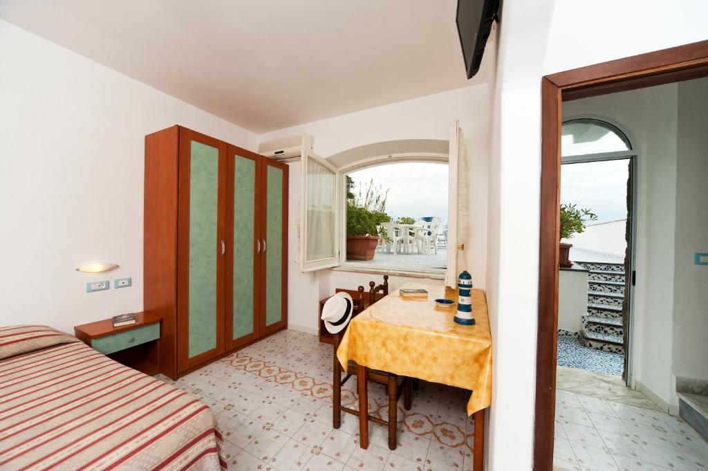 une chambre avec une table, un lit et une fenêtre dans l'établissement Residence Hotel La Rotonda Sul Mare, à Ischia