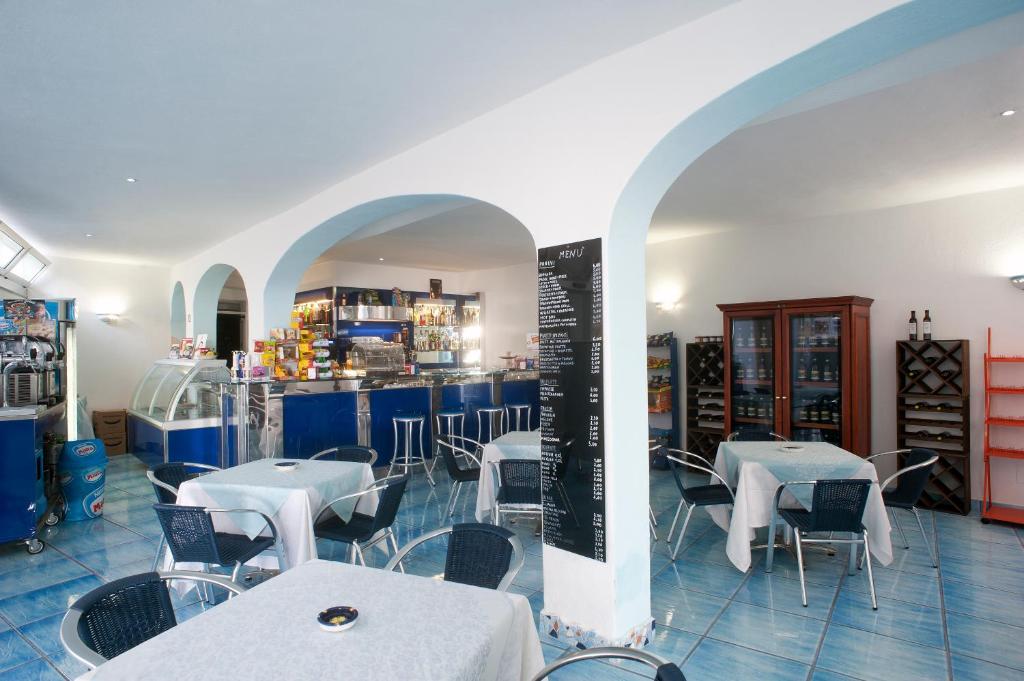 un restaurant avec des tables et des chaises et un bar dans l'établissement Residence Hotel La Rotonda Sul Mare, à Ischia