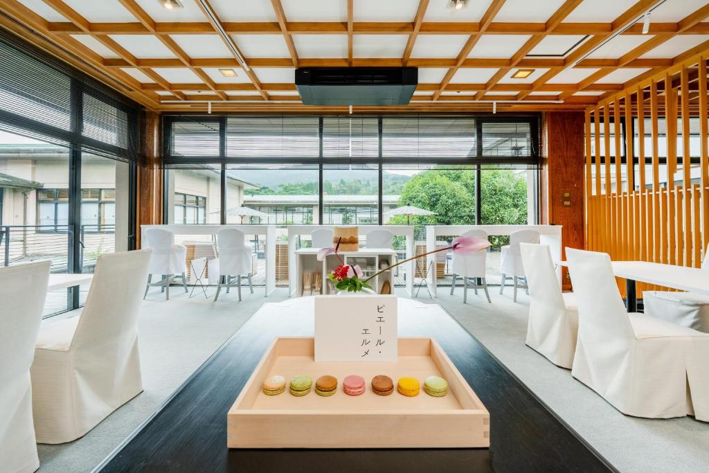 une salle à manger avec des chaises blanches et une table dans l'établissement Wataya Besso, à Ureshino