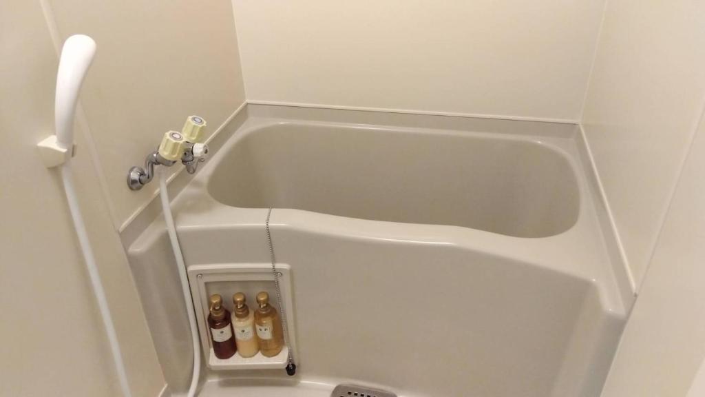 - une baignoire blanche avec des bouteilles de bière dans l'établissement Yura Onsen Yaotome, à Tsuruoka 37 autres photos