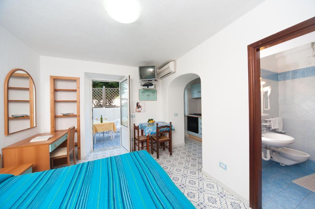 - une chambre avec un lit bleu et une salle de bains dans l'établissement Residence Hotel La Rotonda Sul Mare, à Ischia