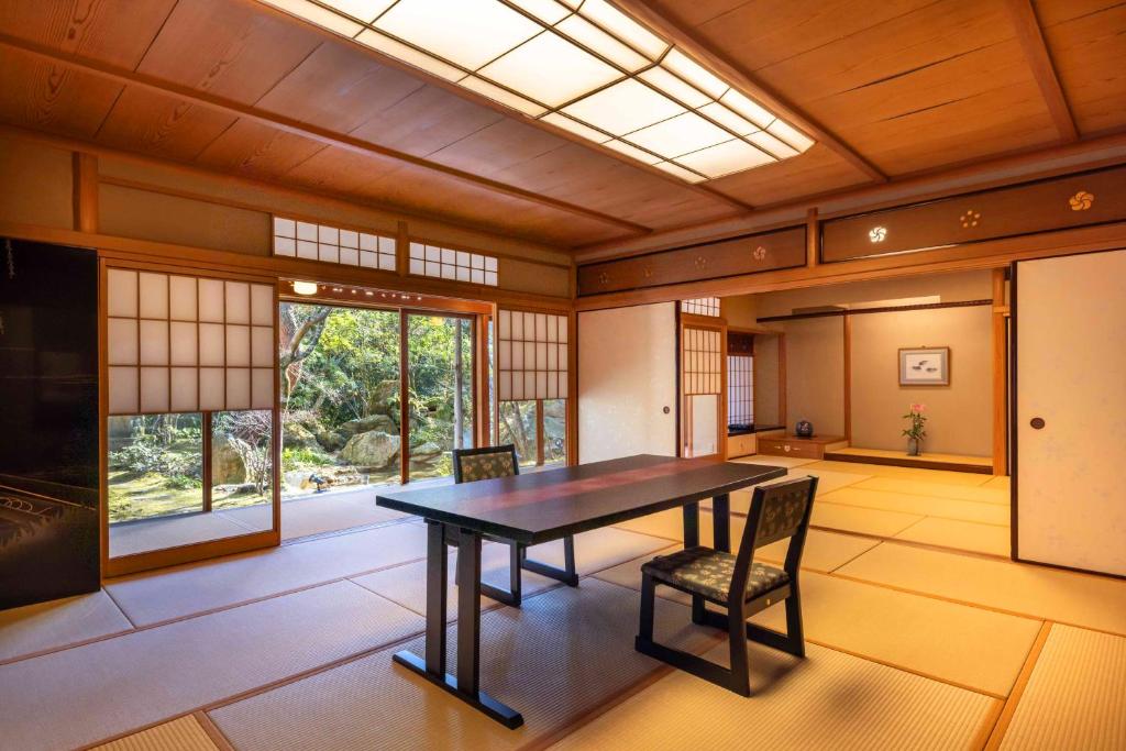 une salle à manger avec une table et des chaises dans l'établissement 旅亭 半水盧, à Unzen