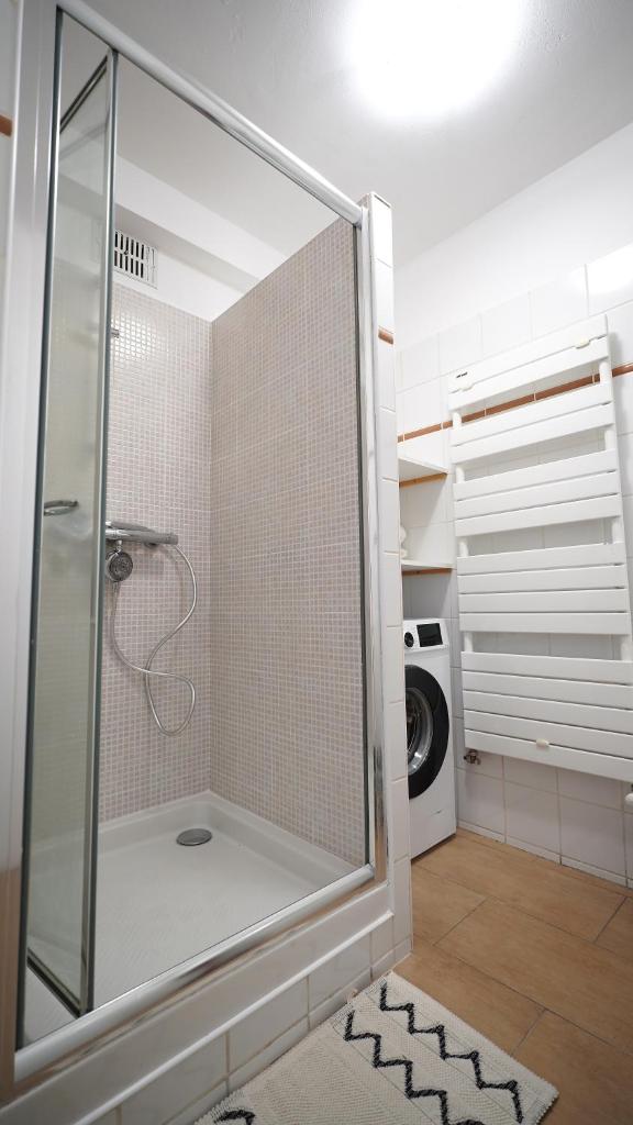 une douche avec une porte vitrée dans une salle de bain dans l'établissement Appartement bien-être Issoire, à Issoire