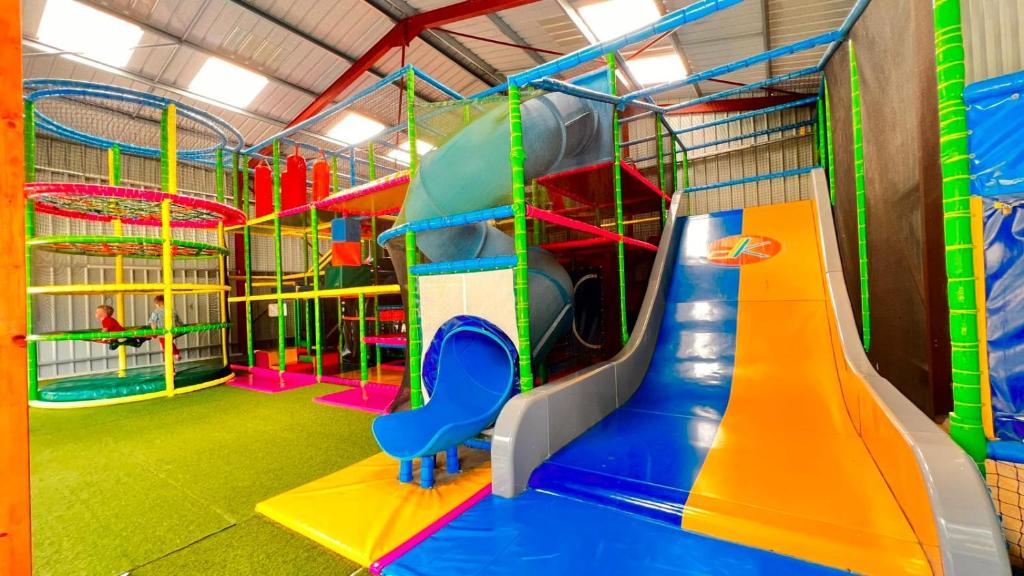 une salle de jeux avec un toboggan et un toboggan dans l'établissement Mobil Home XXL 4 chambres - Camping Country Park, à Touquin