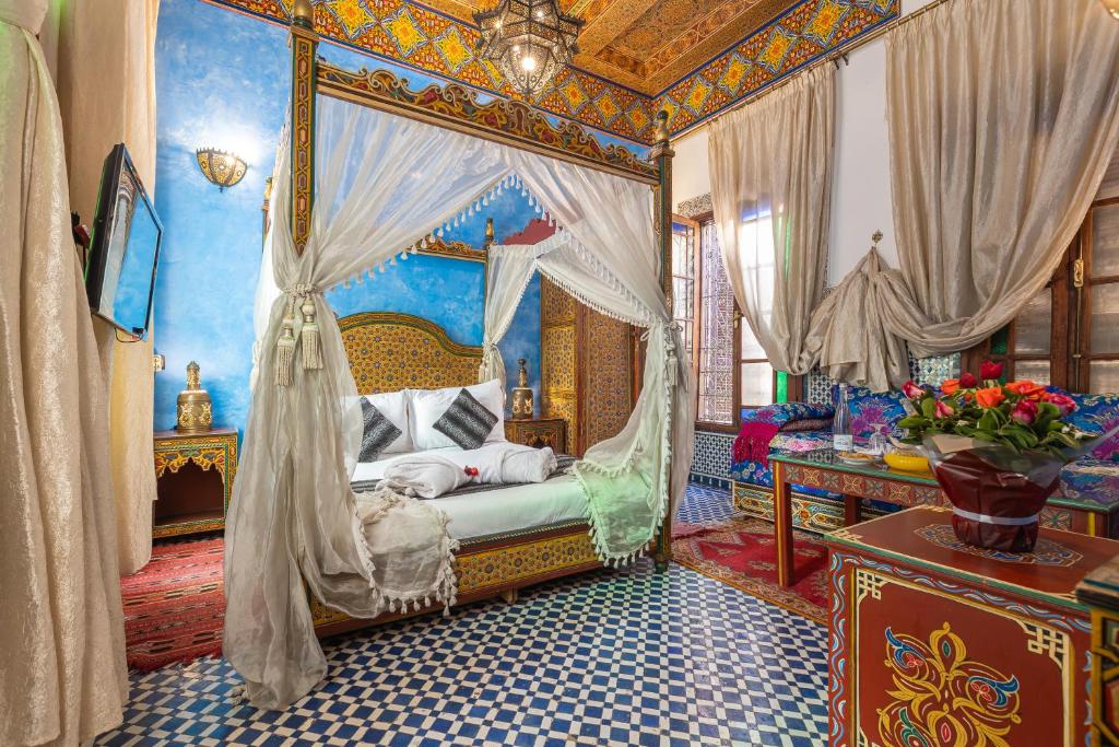 une chambre avec un lit à baldaquin dans une pièce dans l'établissement Riad Ghita, à Fès