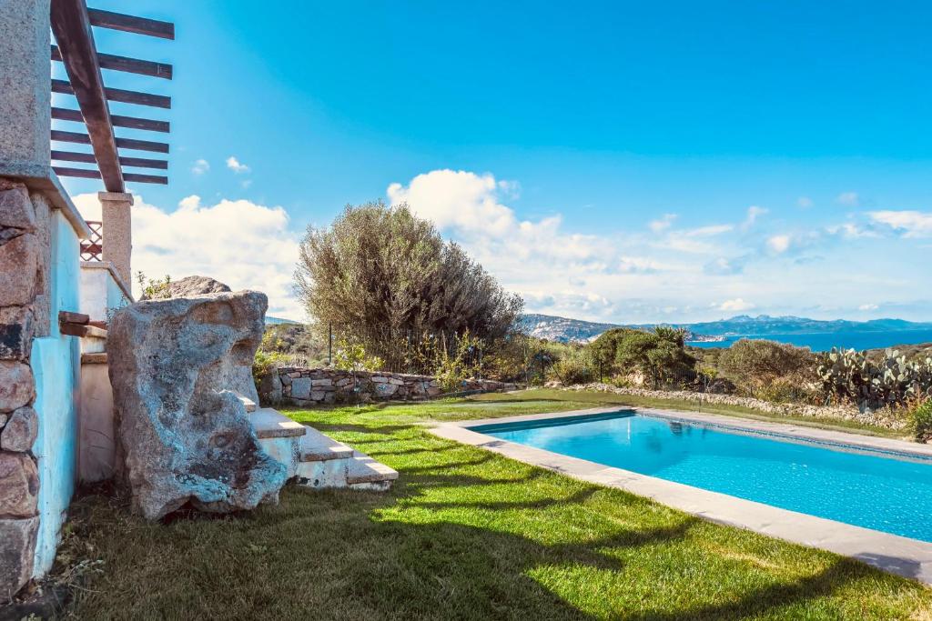 une piscine dans une cour à côté d'une maison dans l'établissement Porto Cervo Villas Swimming Pool - Sea View, à Porto Cervo