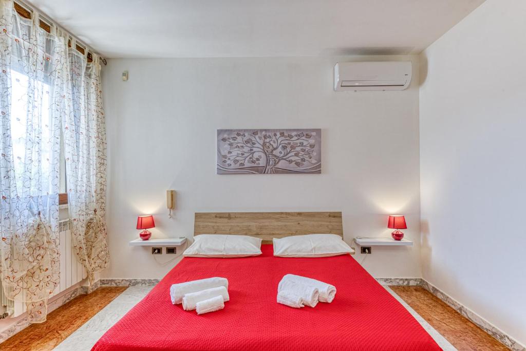une chambre avec un lit rouge avec des serviettes dessus dans l'établissement Villa Urso, à Ugento