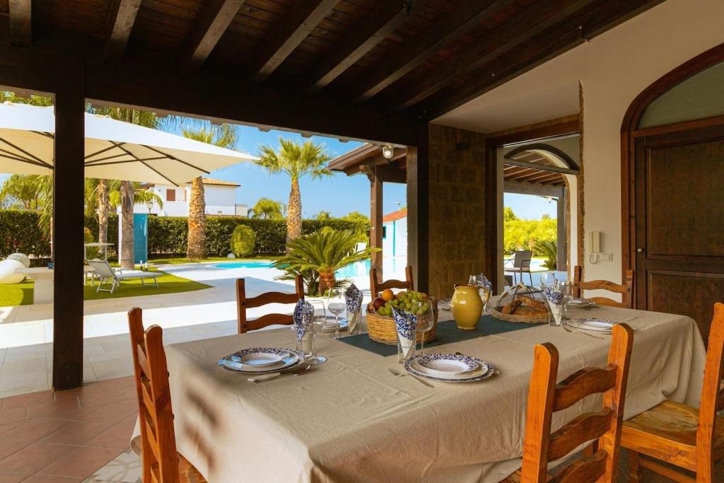 une table à manger avec une nappe blanche et une table dans l'établissement Villa Oxidiana with pool and garden, à Campofelice di Roccella