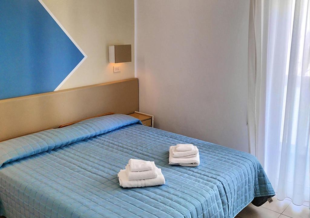 une chambre avec un lit avec deux serviettes dessus dans l'établissement Hotel Cà Vanni, à Rimini