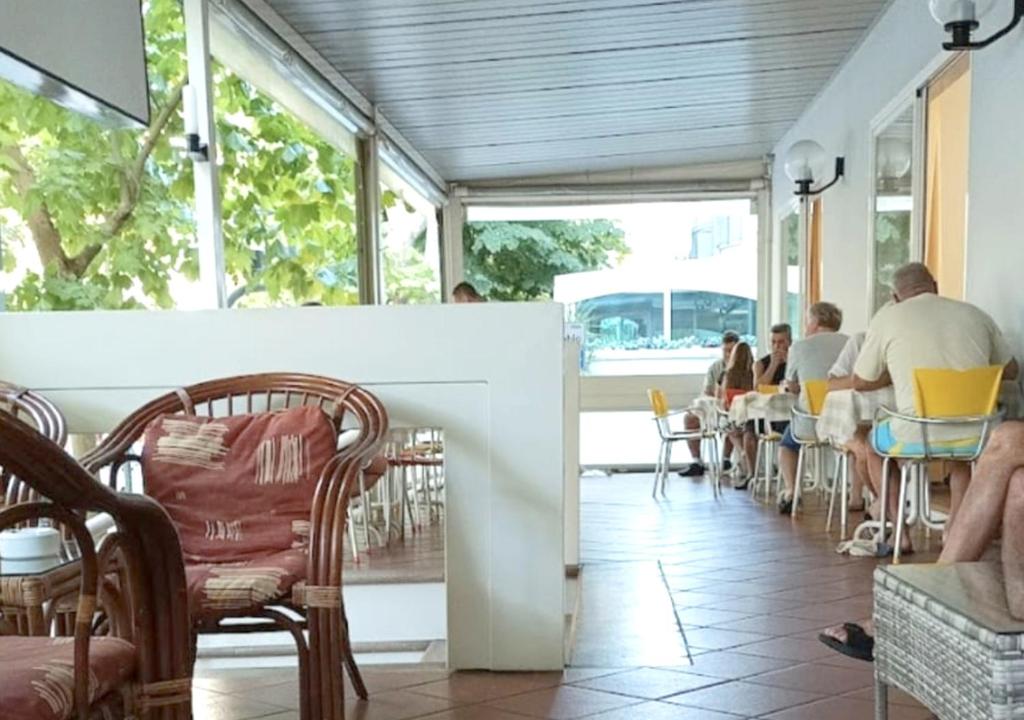 un groupe de personnes assises à des tables dans un restaurant dans l'établissement Hotel Cà Vanni, à Rimini 29 autres photos