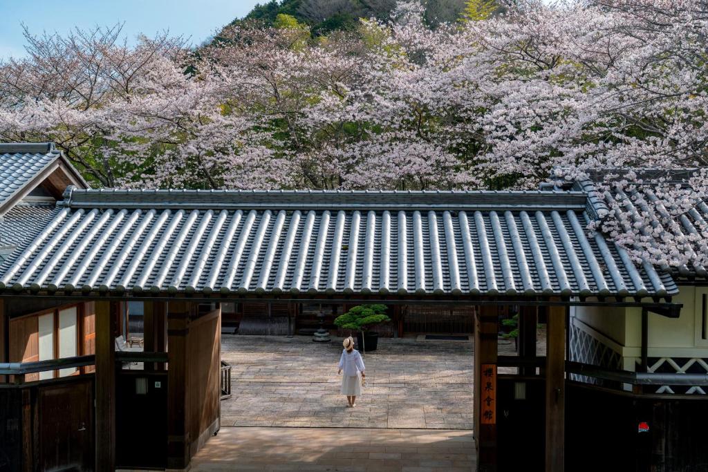 Une femme traverse l'entrée d'un bâtiment avec des akura dans l'établissement Oukai Villa Izumi, à Izumi 37 autres photos