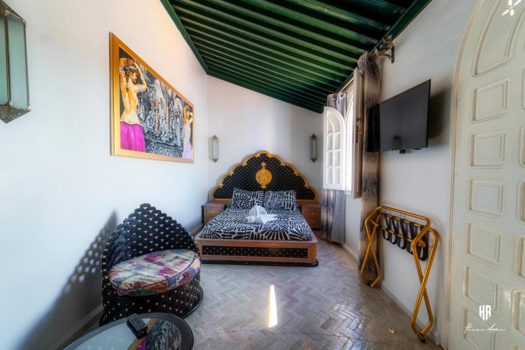 une chambre avec un lit et des chaises dans une pièce dans l'établissement PALACIO AL ANDALUS, à Chefchaouen