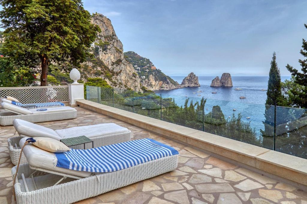 un patio avec des chaises longues et une vue sur l'océan dans l'établissement Villa Nicole by My Villa Collection, à Capri
