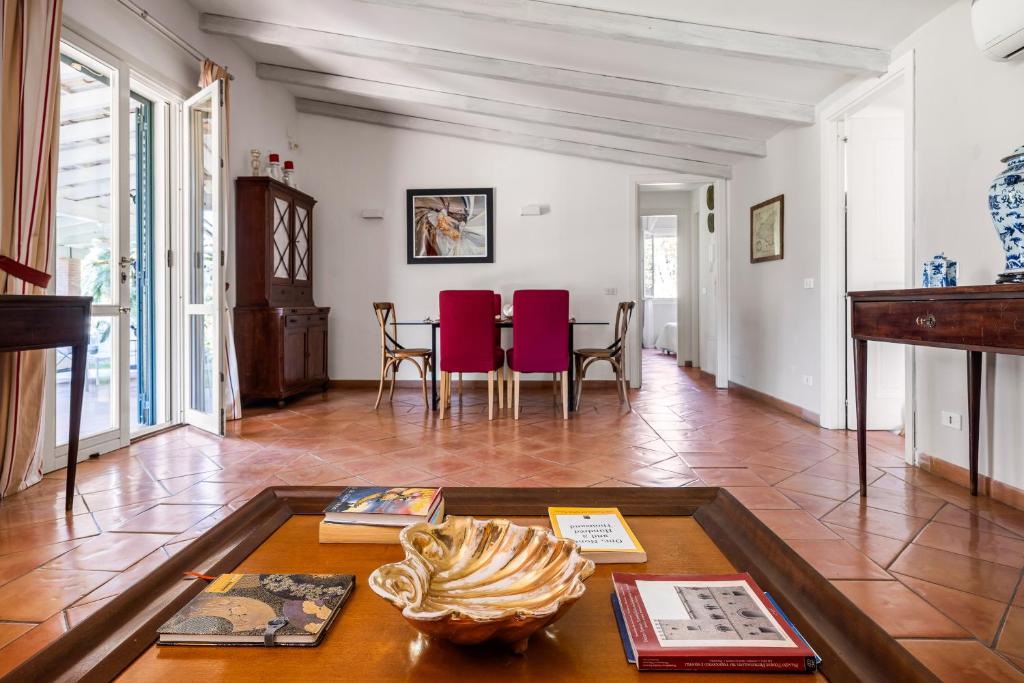 un salon avec une table et des chaises rouges dans l'établissement Solemar Sicilia - Villa Mondello, à Palerme