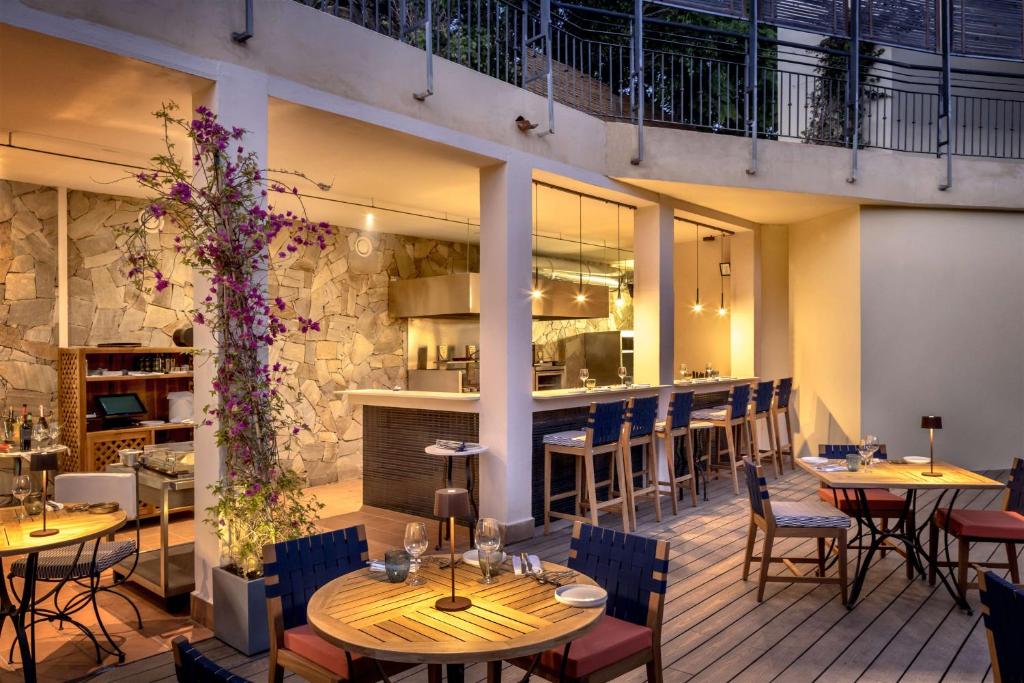 un restaurant avec des tables et des chaises et un bar dans l'établissement Veridia Resort Sardinia, a member of Radisson Individuals, à Chia