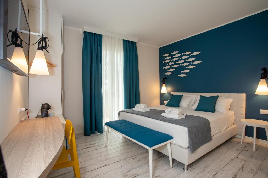 une chambre avec un grand lit avec un mur bleu dans l'établissement Hotel Villa Eugenia - 3 Stelle Superior con Private SPA e Piscina, à Lido di Jesolo