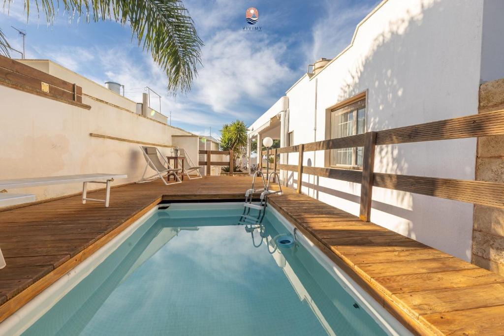 une maison avec une piscine et une terrasse en bois dans l'établissement Villa La Palma By Vivimy, à Taviano