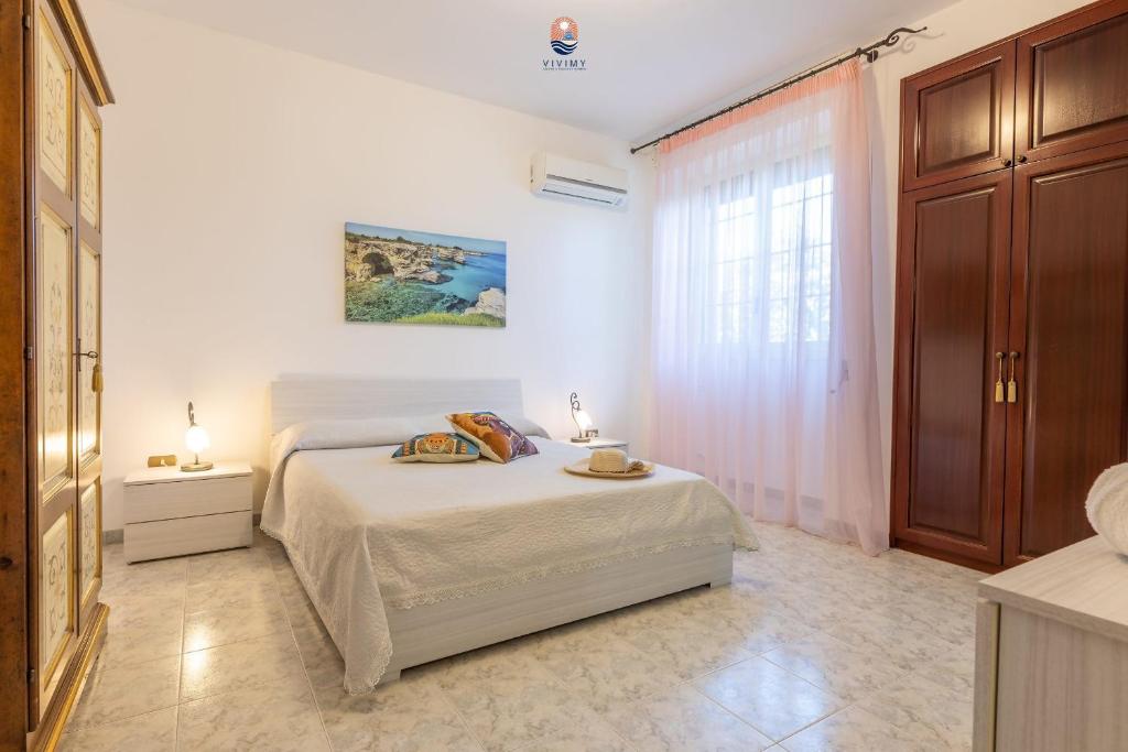 une chambre blanche avec un lit et une fenêtre dans l'établissement Villa La Palma By Vivimy, à Taviano