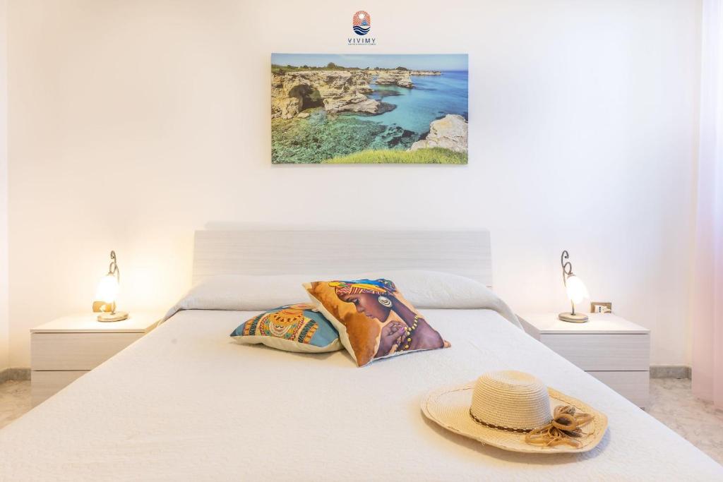 - une chambre avec un lit avec un chapeau et deux lampes dans l'établissement Villa La Palma By Vivimy, à Taviano 26 autres photos