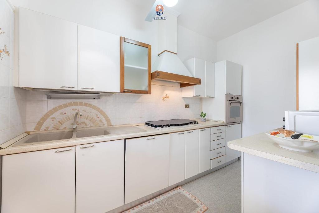une cuisine blanche avec des armoires blanches et un évier dans l'établissement Villa La Palma By Vivimy, à Taviano
