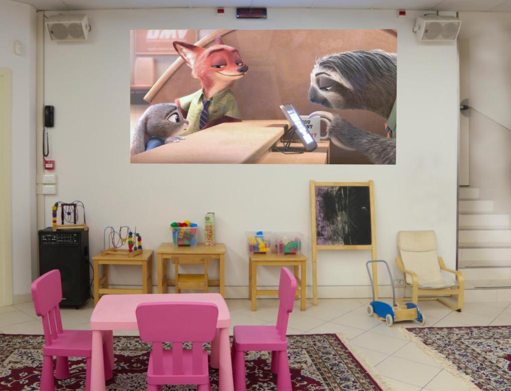 une chambre avec une table, des chaises roses et un tableau dans l'établissement Hotel Leoni, à Rimini
