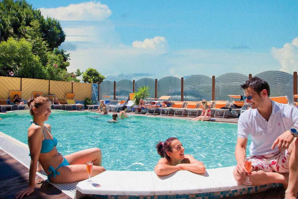 un groupe de personnes assises dans une piscine dans l'établissement Hotel Leoni, à Rimini
