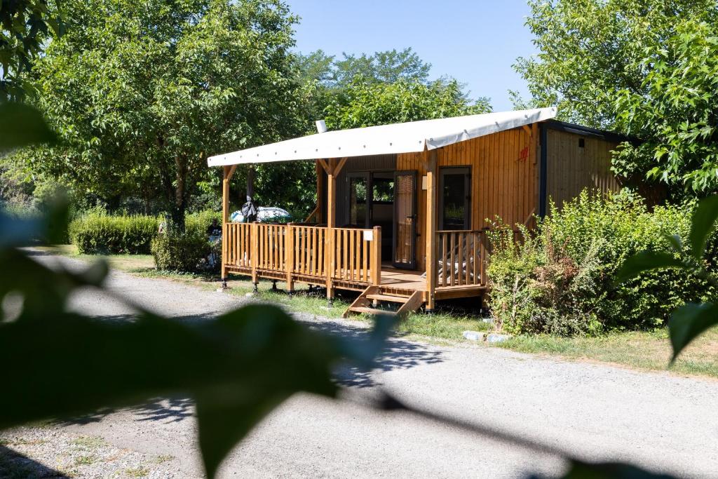 une cabane en bois avec une véranda dans les arbres dans l'établissement Camping Sites et Paysages Les Prés Hauts, à Sisteron
