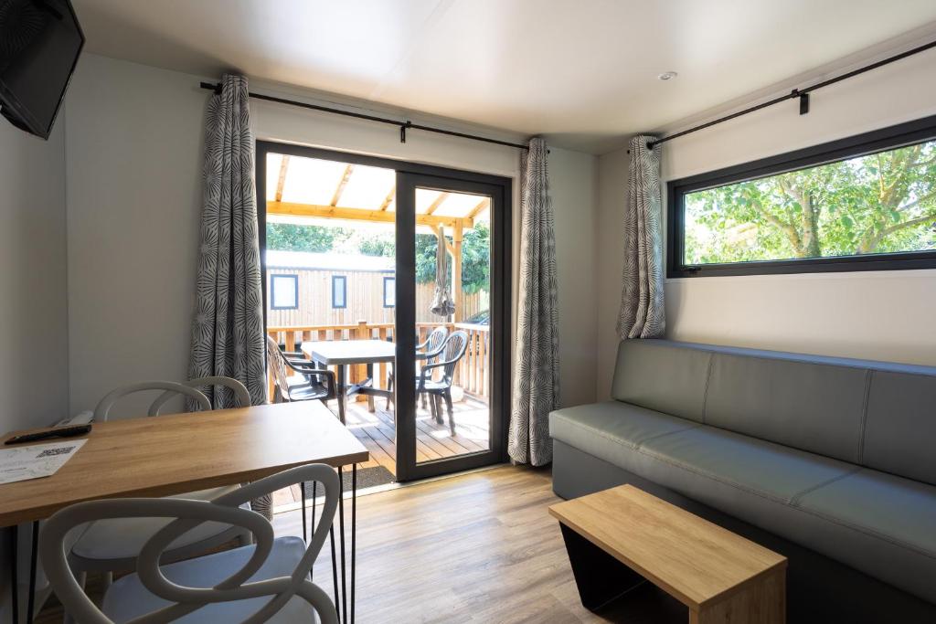un salon avec un canapé et une table dans l'établissement Camping Sites et Paysages Les Prés Hauts, à Sisteron