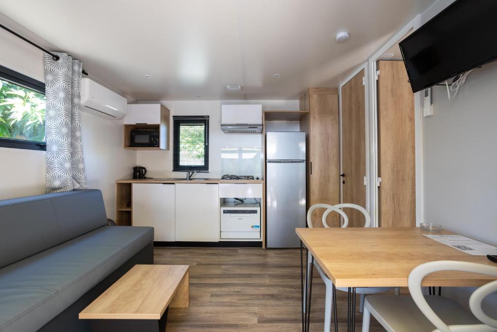 une cuisine et une salle à manger avec un canapé et une table dans l'établissement Camping Sites et Paysages Les Prés Hauts, à Sisteron 37 autres photos