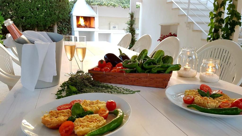 une table avec des assiettes de nourriture et un panier de légumes dans l'établissement Villa Gina by Perle di Puglia, à Torre San Giovanni