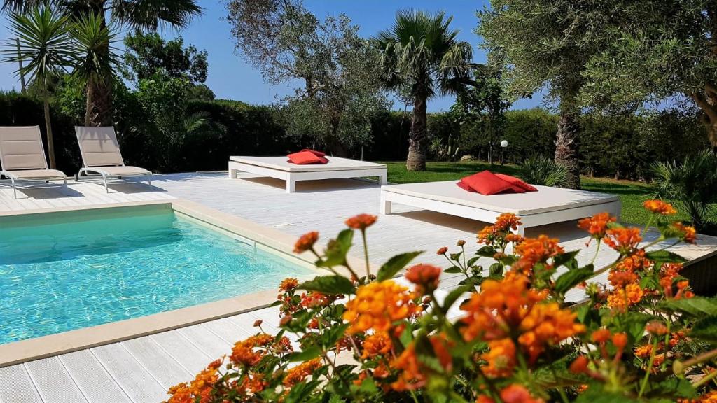 - une piscine avec 2 lits et quelques fleurs dans l'établissement Villa Gina by Perle di Puglia, à Torre San Giovanni 13 autres photos
