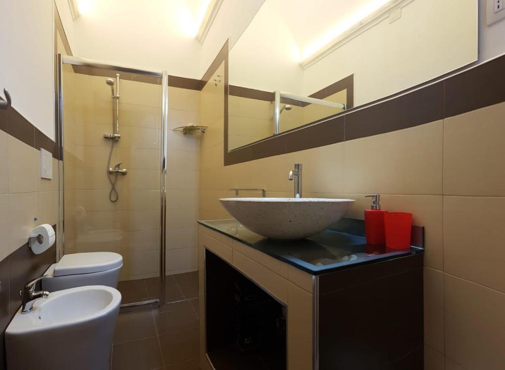 une salle de bain avec un lavabo, des toilettes et un miroir dans l'établissement Villa Gina by Perle di Puglia, à Torre San Giovanni