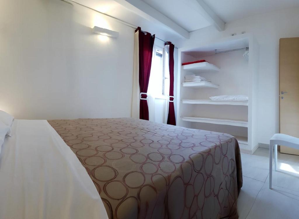 - une chambre avec un lit, une fenêtre et des étagères dans l'établissement Villa Gina by Perle di Puglia, à Torre San Giovanni