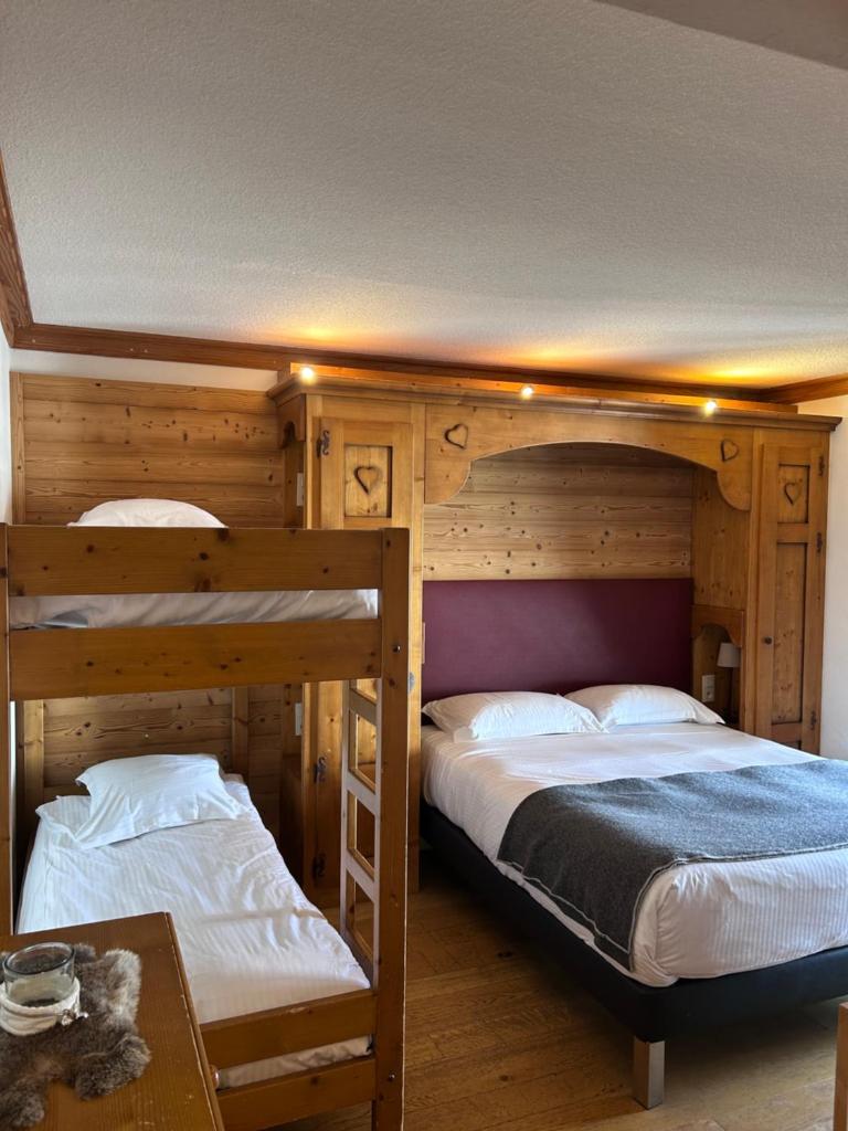 une chambre avec deux lits superposés et une table dans l'établissement Bellevue, aux Gets