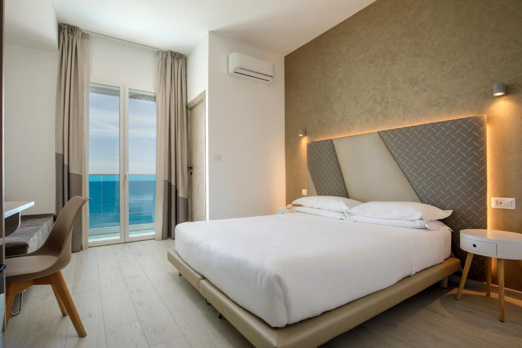 une chambre avec un lit, un bureau et une fenêtre dans l'établissement Hotel Tirreno, à Latina