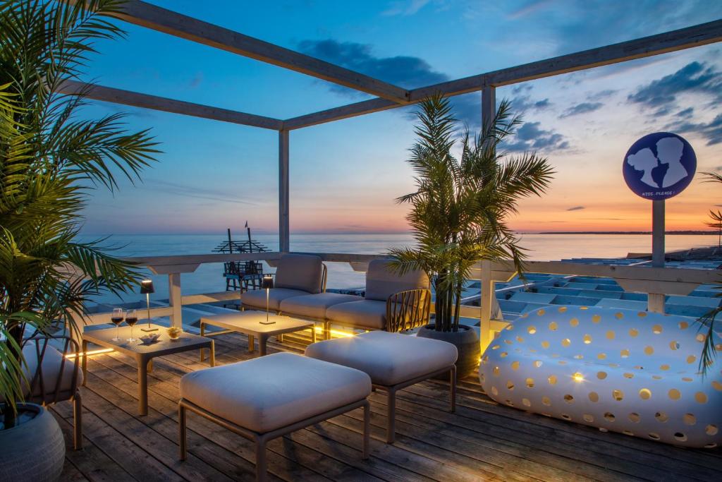 un patio avec vue sur l'océan au coucher du soleil dans l'établissement Hotel Tirreno, à Latina