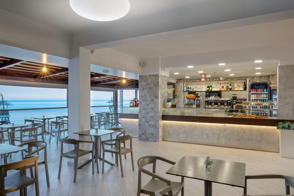 un restaurant avec des tables et des chaises et un bar dans l'établissement Hotel Tirreno, à Latina