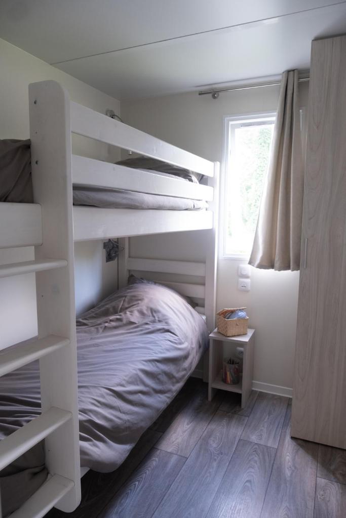 - une chambre avec des lits superposés blancs et une fenêtre dans l'établissement Mobil Home XXL 4 chambres - Camping Country Park, à Touquin