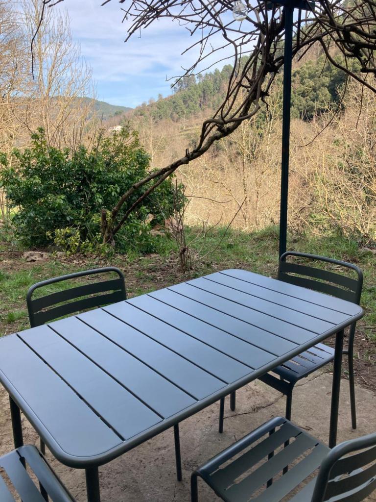 - une table de pique-nique bleue avec 2 chaises à côté dans l'établissement Gîte Jules VERNE, à Saint-Sauveur-de-Montagut